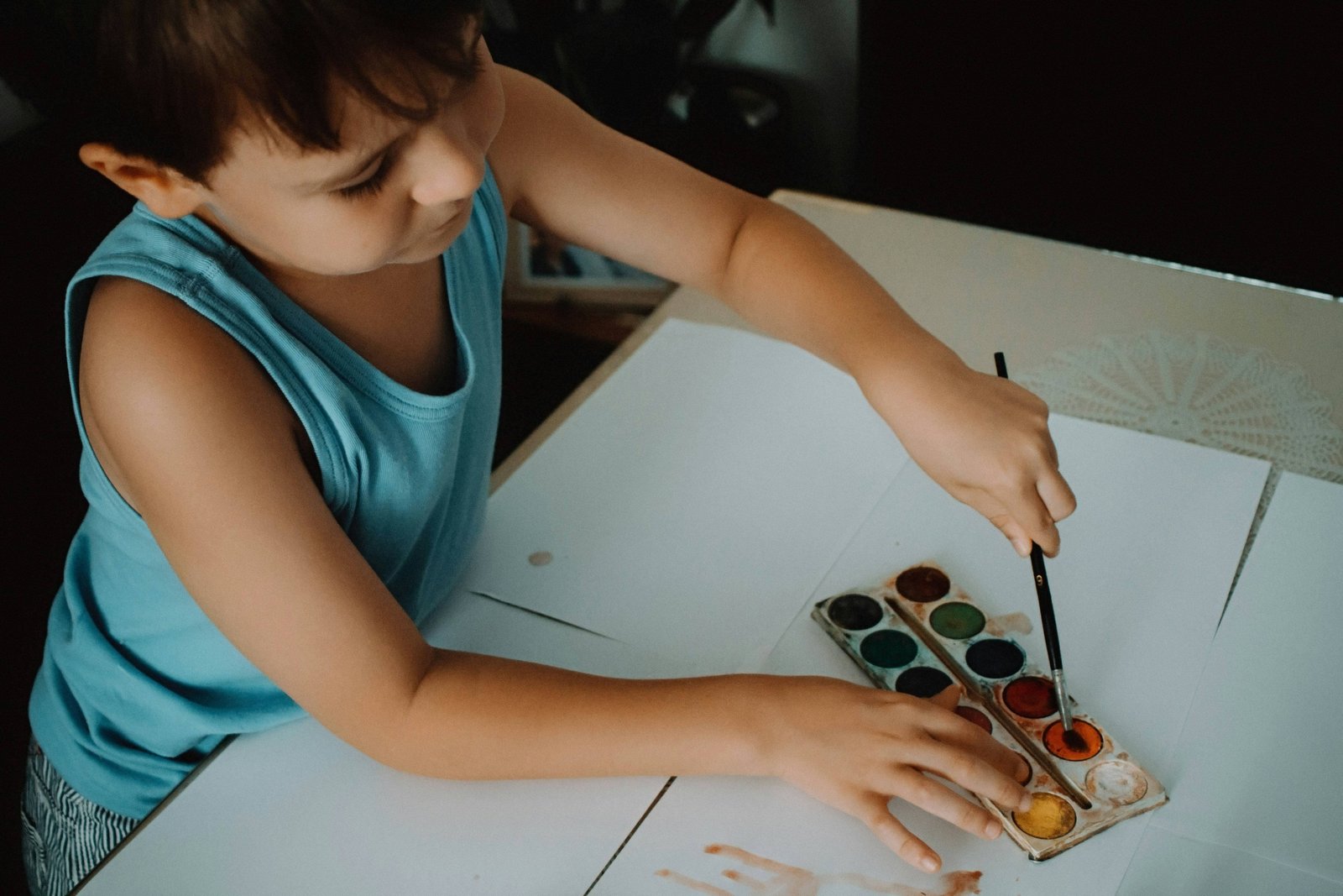 Boy painting with a watercolour set